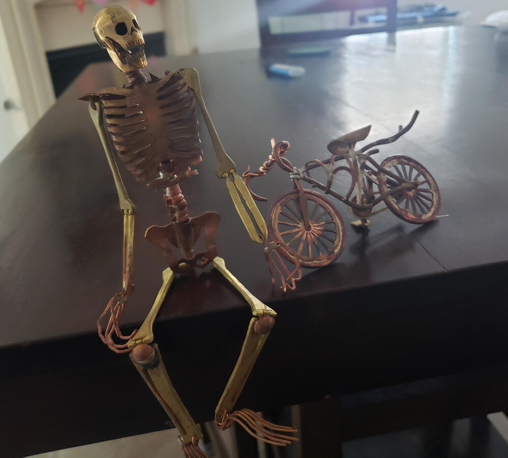 Brass skeleton and bicycle.